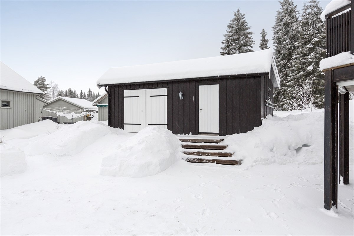 En liten trapp i terrenget opp til garasjen, som også har en praktisk bod Galleribilde