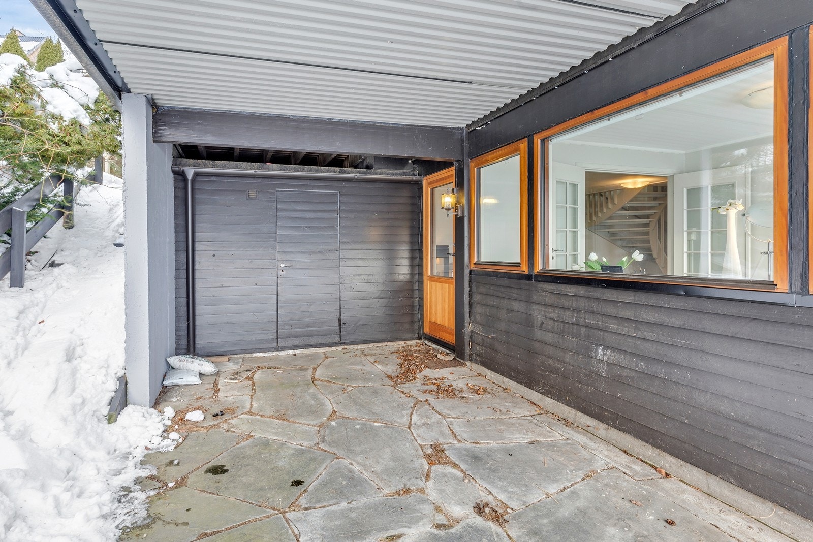 Bod og hellelagt uteplass utenfor stuen i underetasjen Galleribilde
