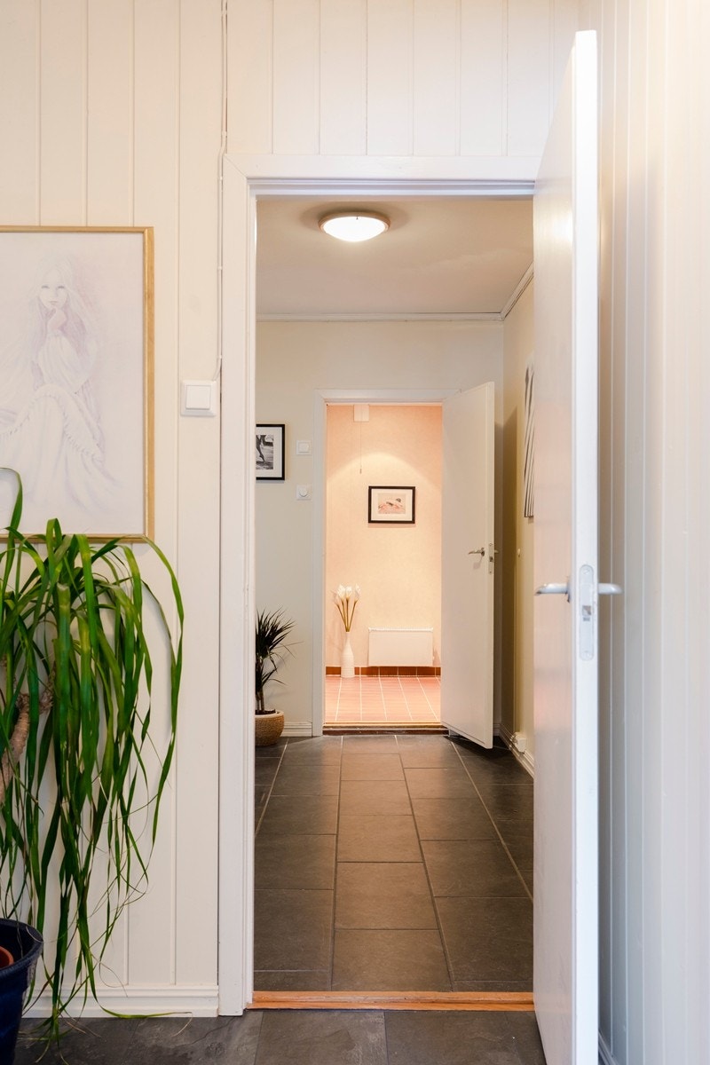 Romslig og innbydende entré med skiferfliser og varmekabler på gulv. Plassbygget skyvedørsgarderobe sikrer rikelig med oppbevaringsplass for yttertøy og sko. Galleribilde