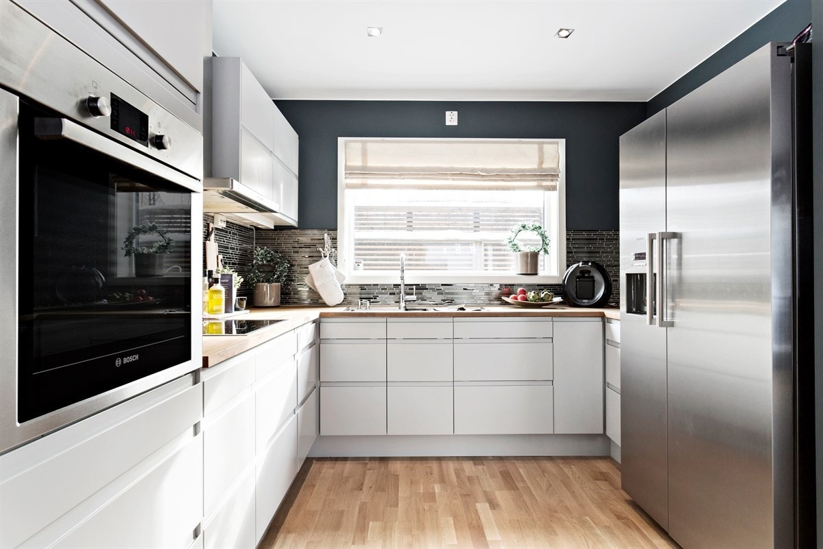 Delikat kjøkken med glatt farget kjøkkeninnredning fra Sigdal. Integrert stekeovn, induksjonstopp og oppvaskmaskin. (Hvitevarer fra Siemens og Bosch). Galleribilde