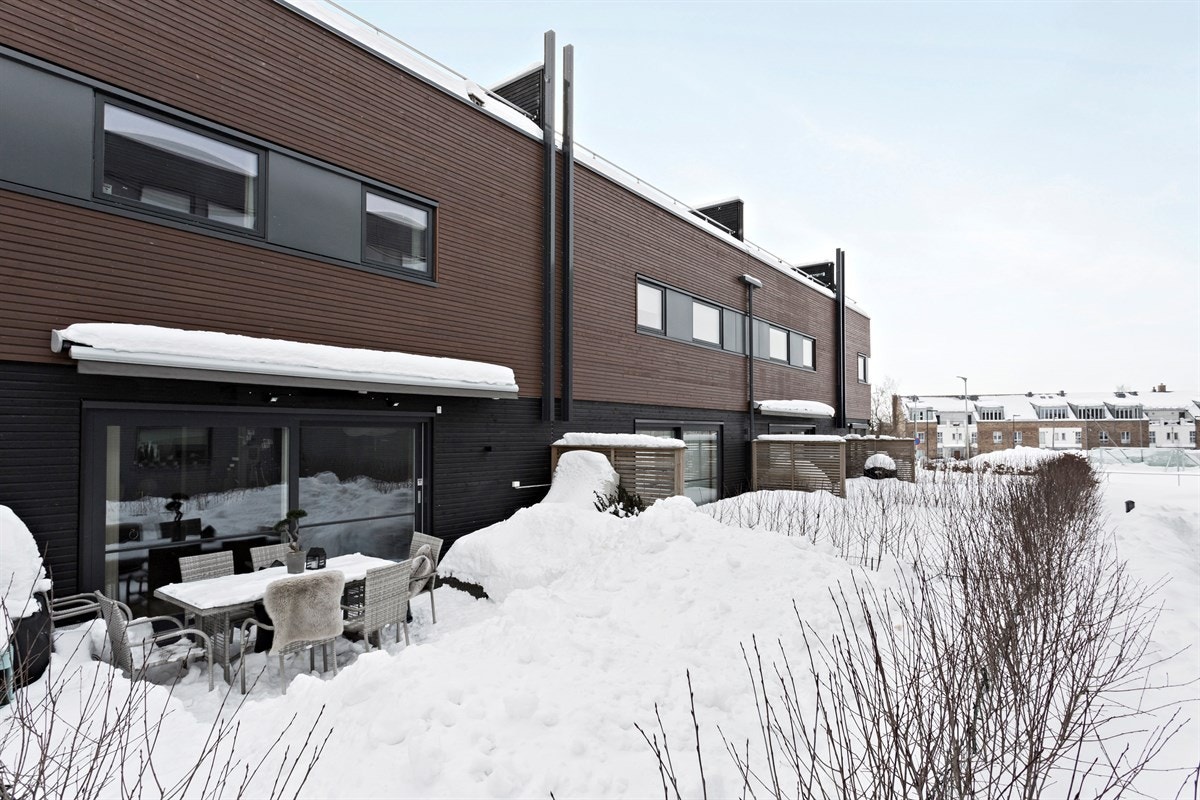 Solrik hellelagt terrasse og plen med utgang fra stuen. Galleribilde