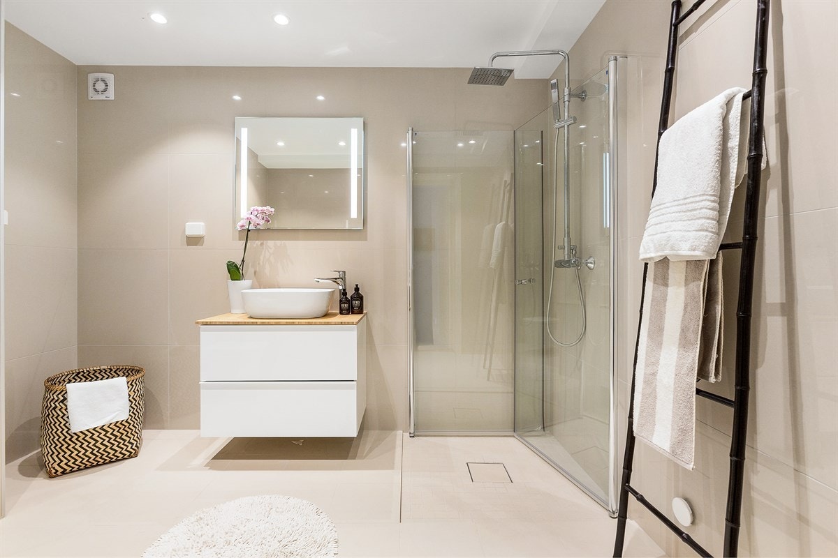 Boligen inneholder et lekkert og delikat bad. Badet har beige fliser på vegger og lyse fliser på gulv med gulvvarme. Galleribilde