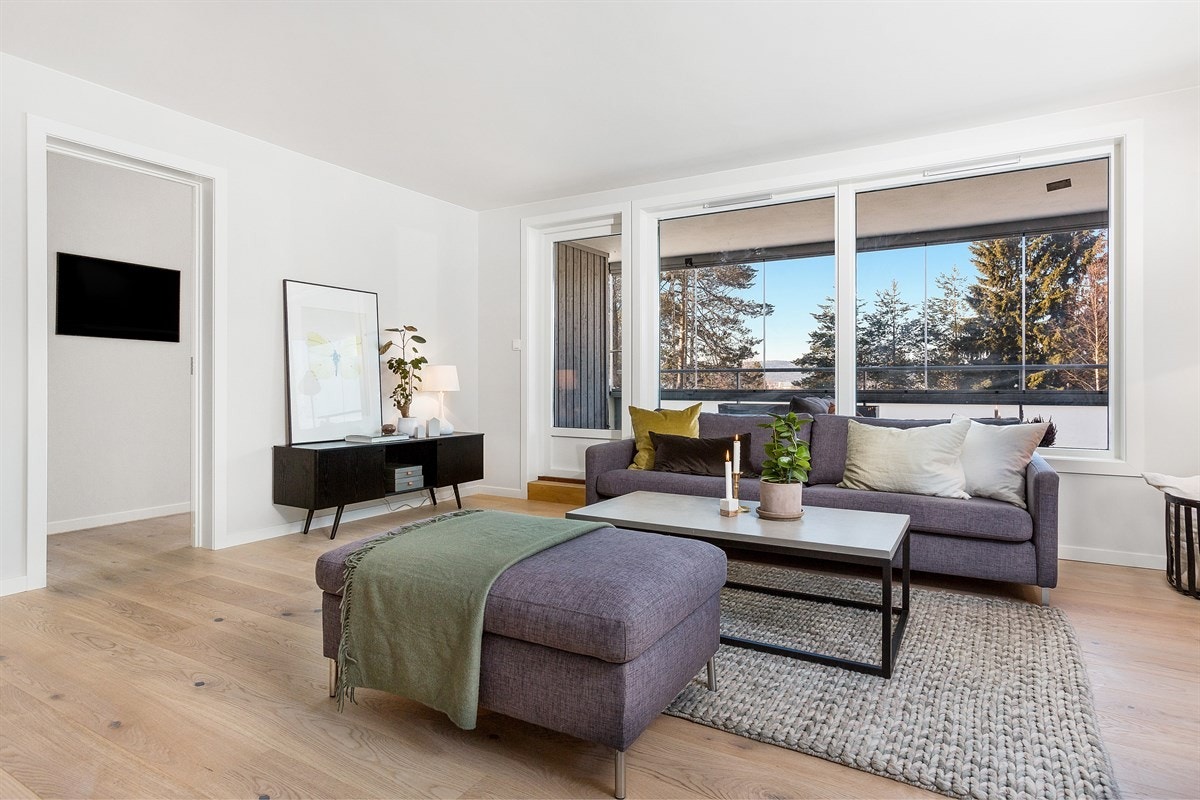 Leiligheten har en hyggelig og innbydende stue med lekkert enstavs parkettgulv, lysmalte vegger og store vindusflater. Galleribilde