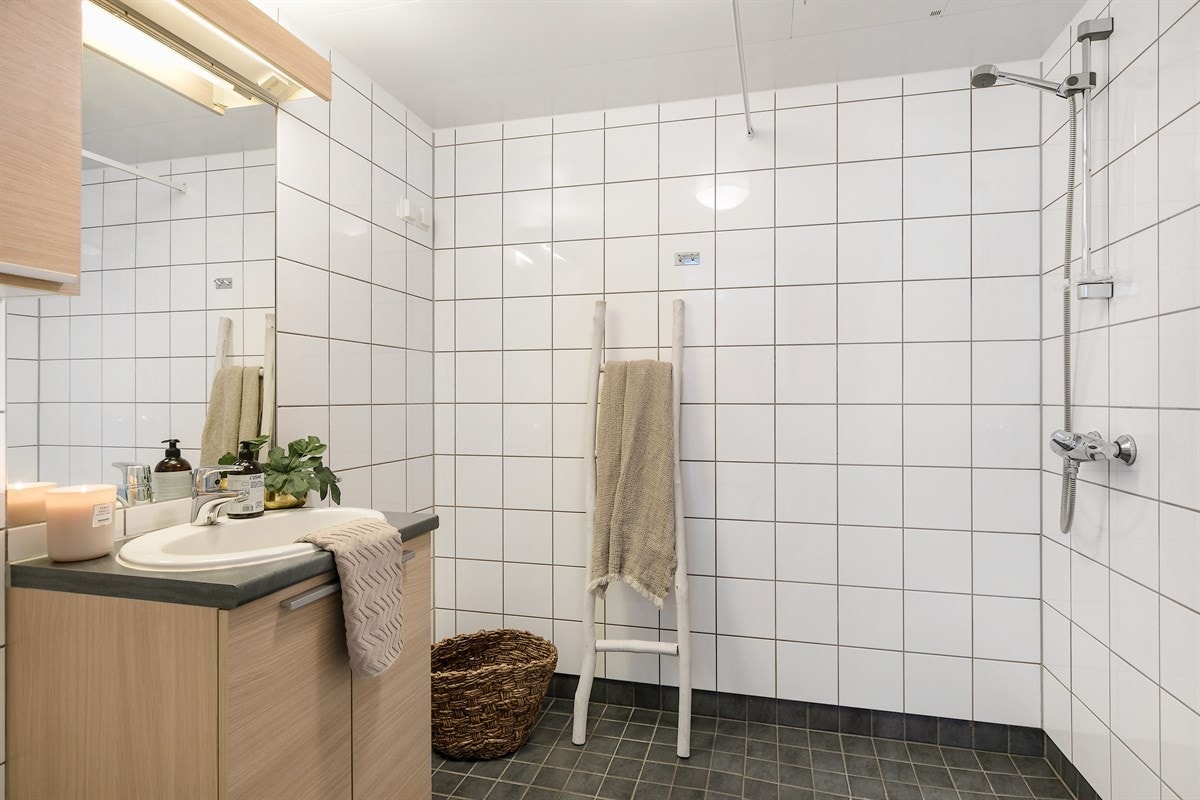 Romslig bad med vegghengt wc, dusjhjørne og opplegg for vaskemaskin. Galleribilde