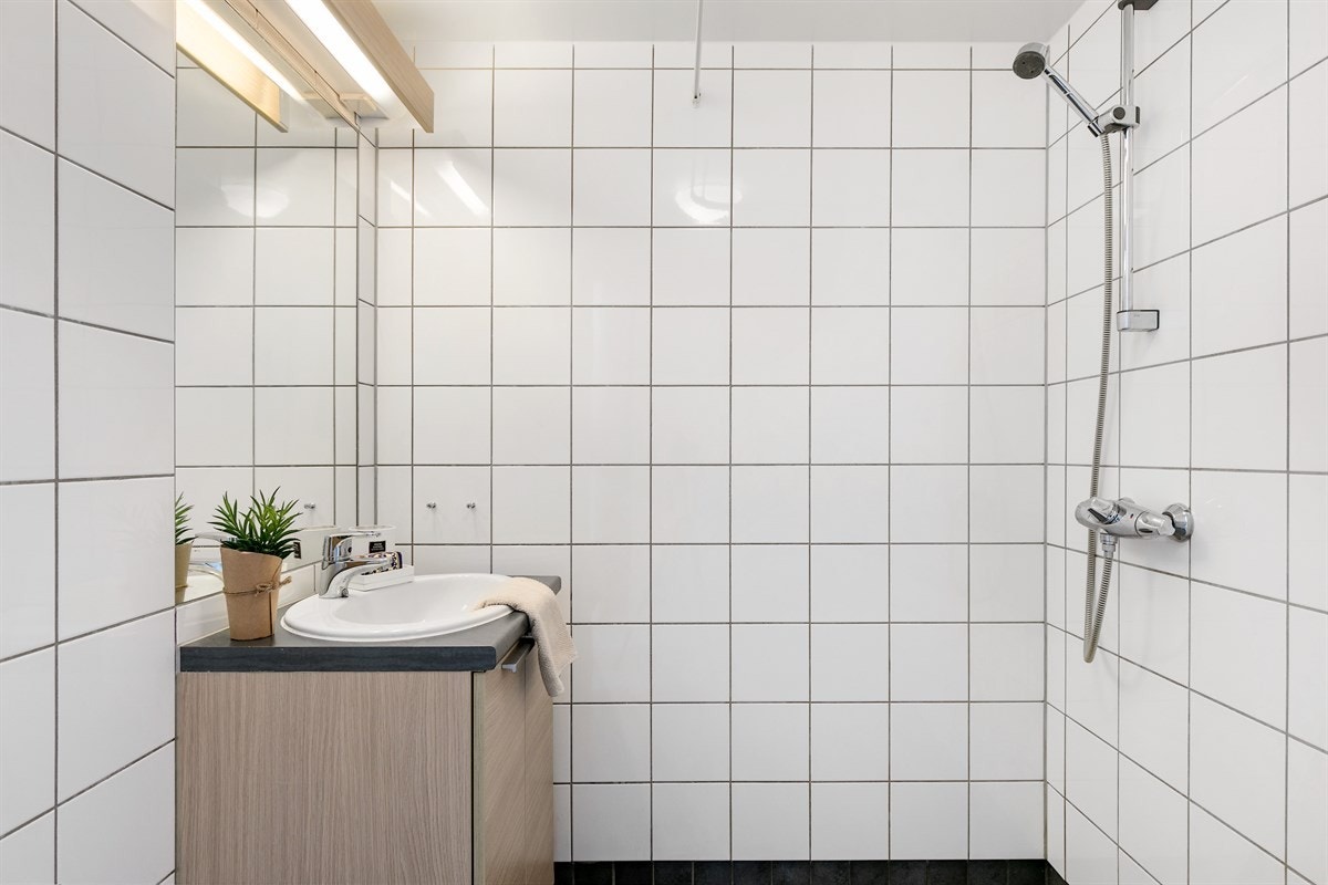 Pent flislagt bad med dusjhjørne og vegghengt wc. Galleribilde