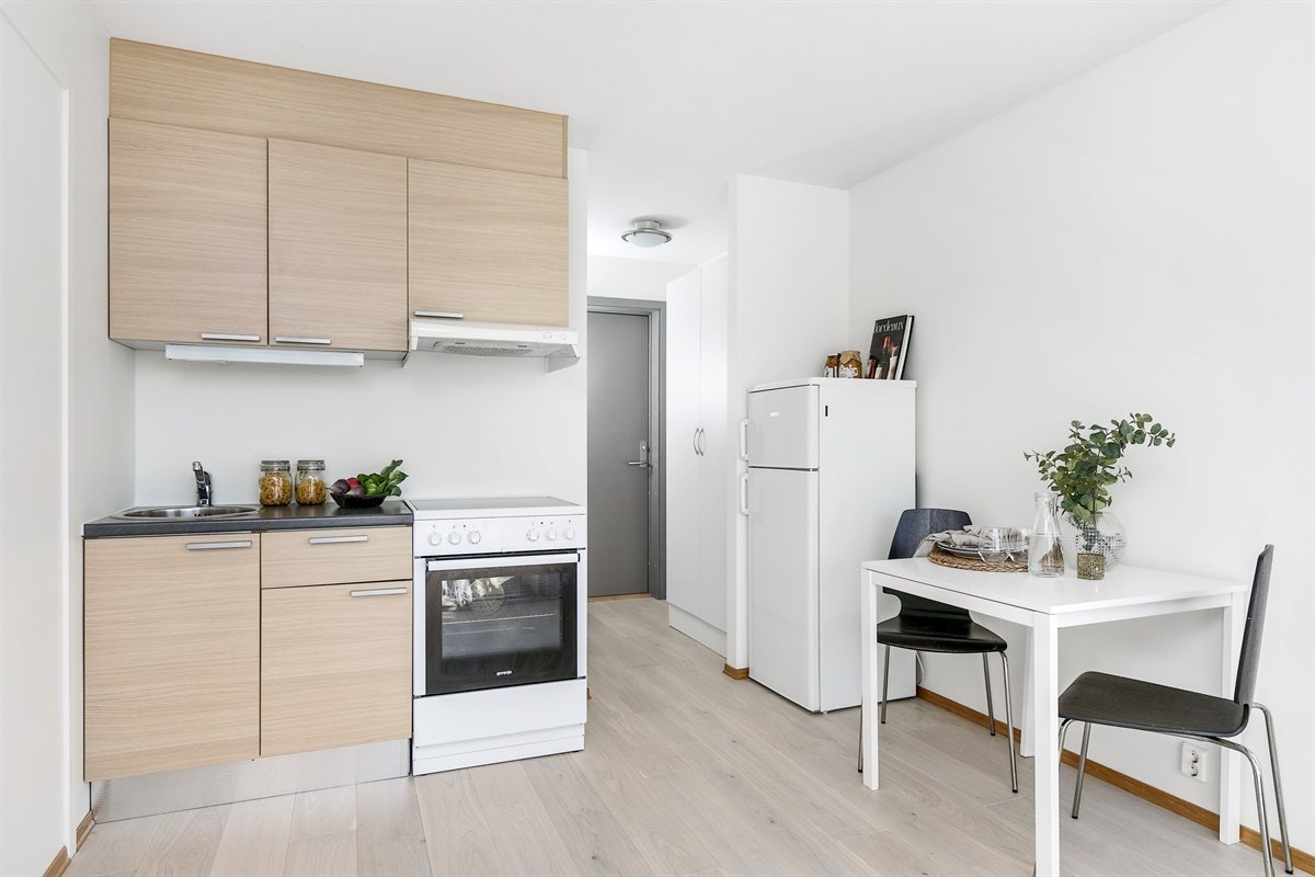 Åpen løsning til kjøkken med pen innredning og plass til spisebord. Galleribilde