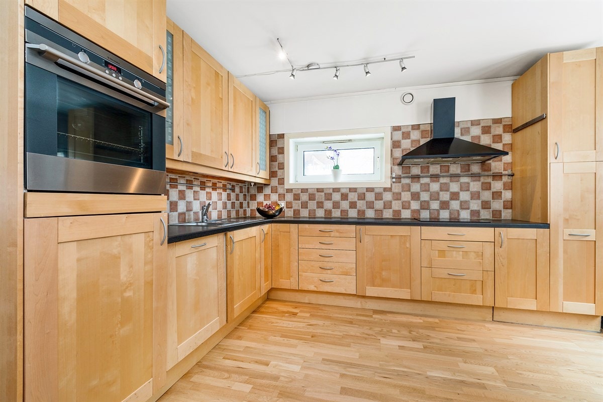 Kjøkken med laminat benkeplater og profilerte fronter med stålhåndtak. God skap- og benkeplass. Galleribilde