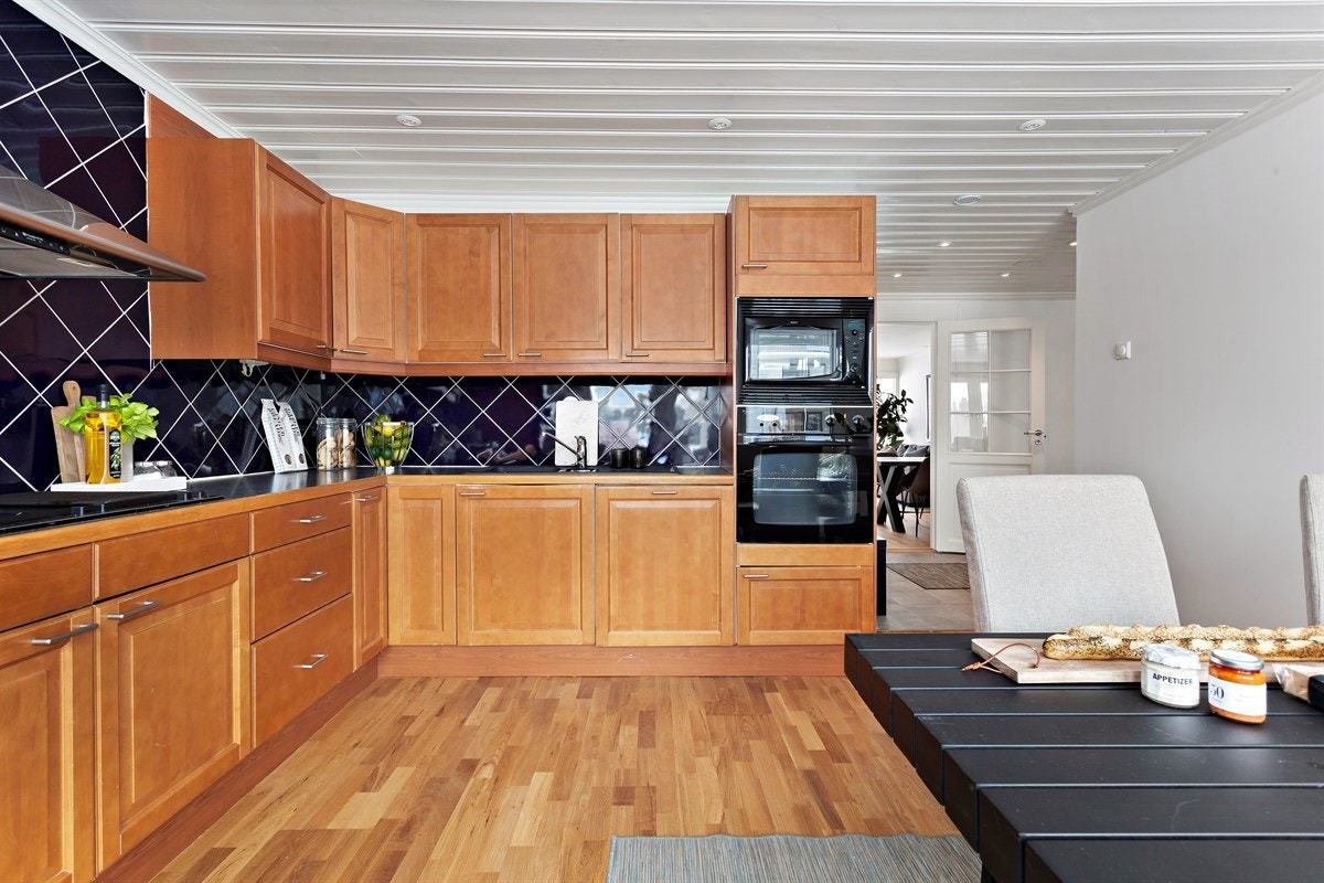 Kjøkkenet er utstyrt med integrert oppvaskmaskin, avtrekksventilator med kullfilter, integrert komfyr, koketopp, gassbluss, frityrkoker/grill og mikrobølgeovn. Galleribilde