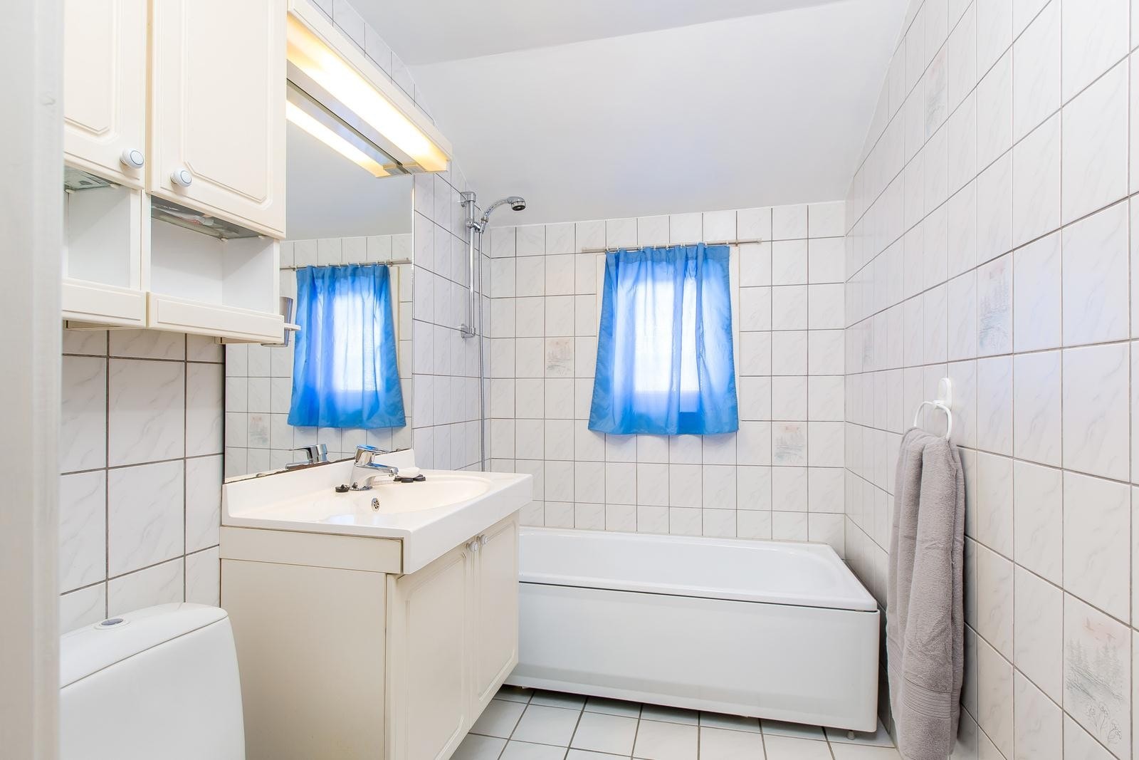 Flislagt bad med badekar. Varmekabler i gulv. Galleribilde