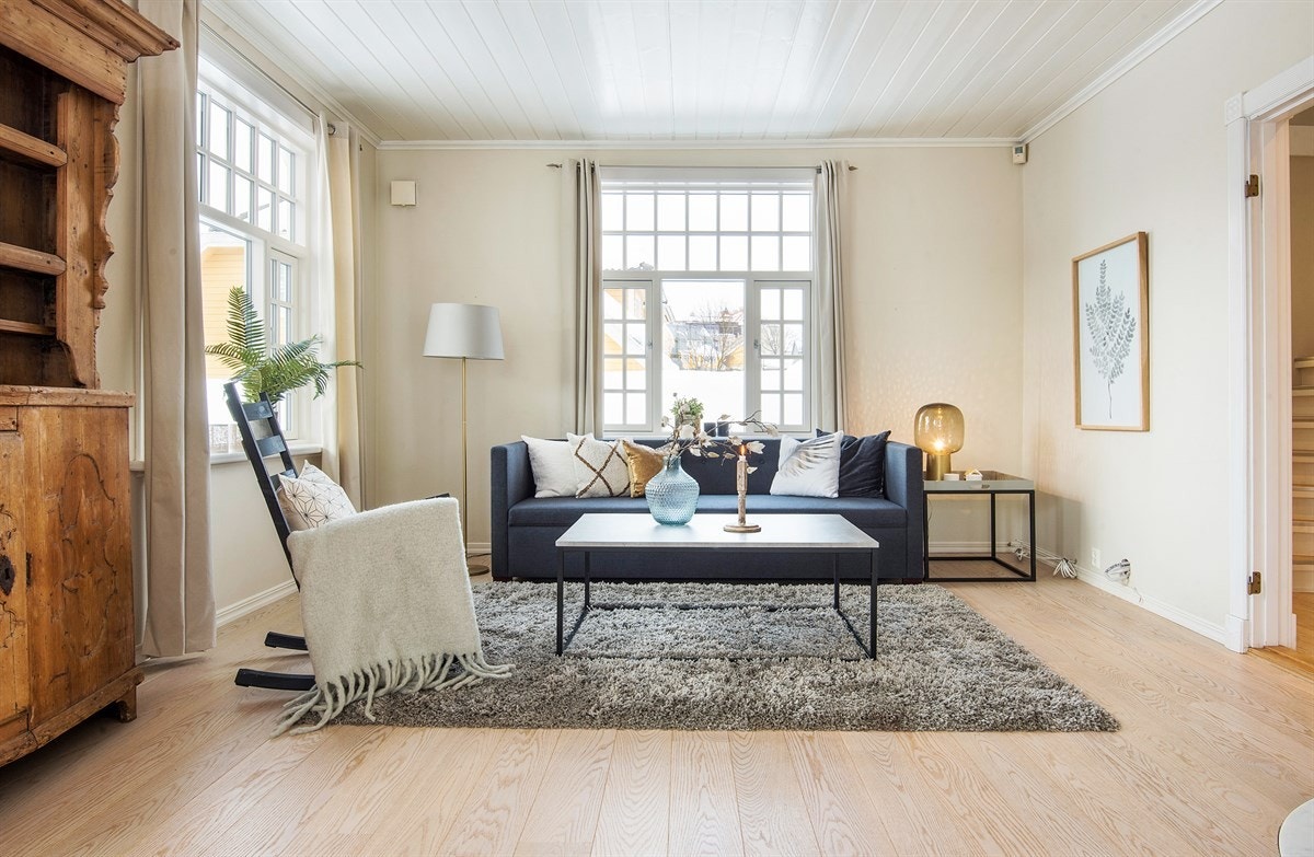 Stuen har store vindusflater og generøs takhøyde, noe som bidrar til å rommet et luftig preg Galleribilde