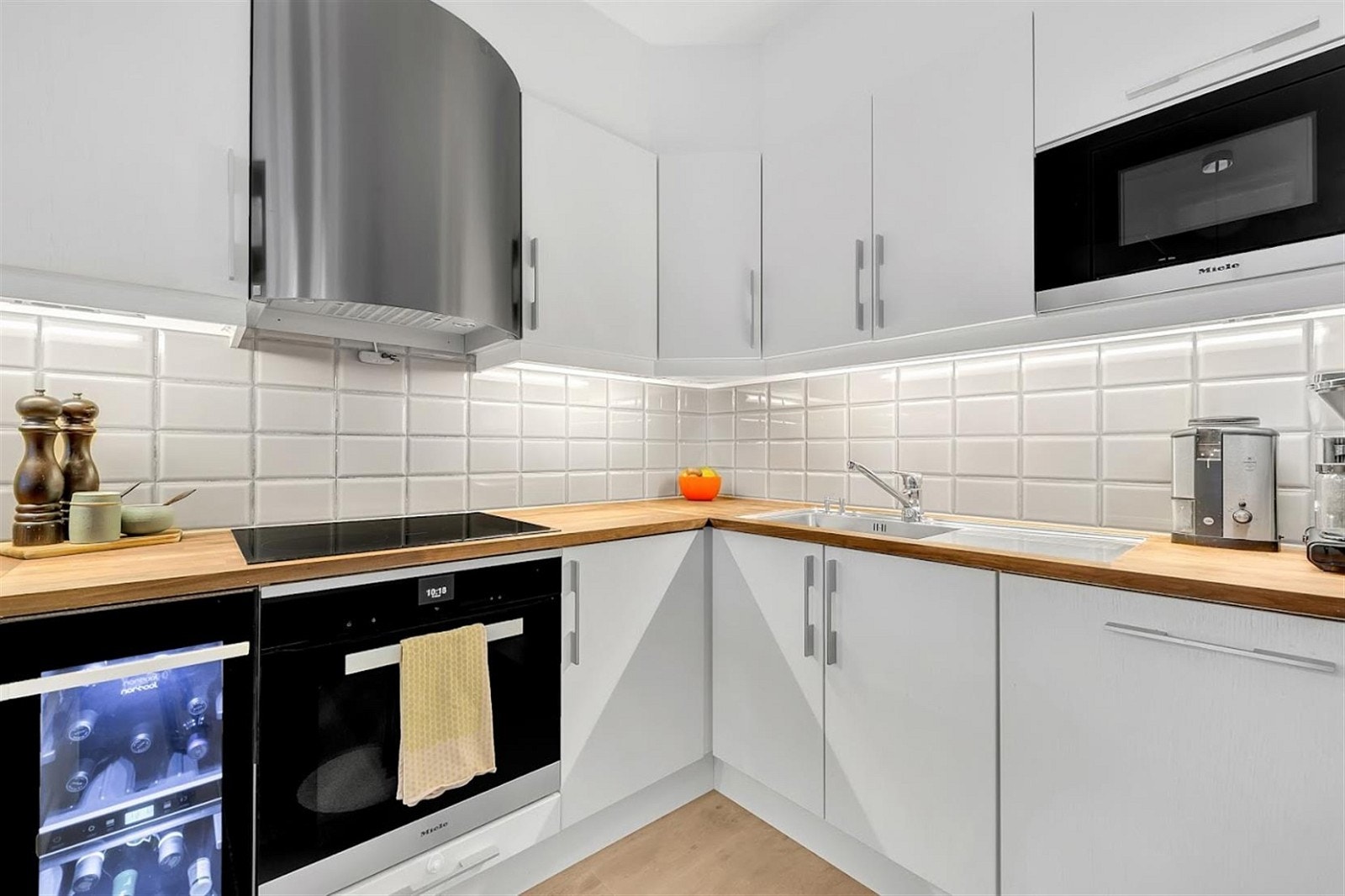 Kjøkkenet har godt med skap og benkeplass. Tidsriktige fliser på vegg. Galleribilde