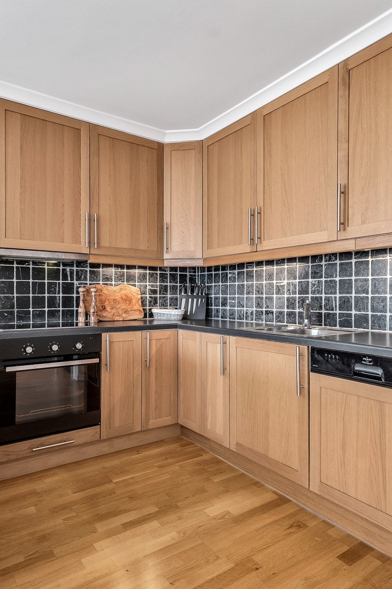 Innredningen har integrerte hvitevarer som oppvaskmaskin, kjøl- og fryseskap, ovn og platetopp Galleribilde