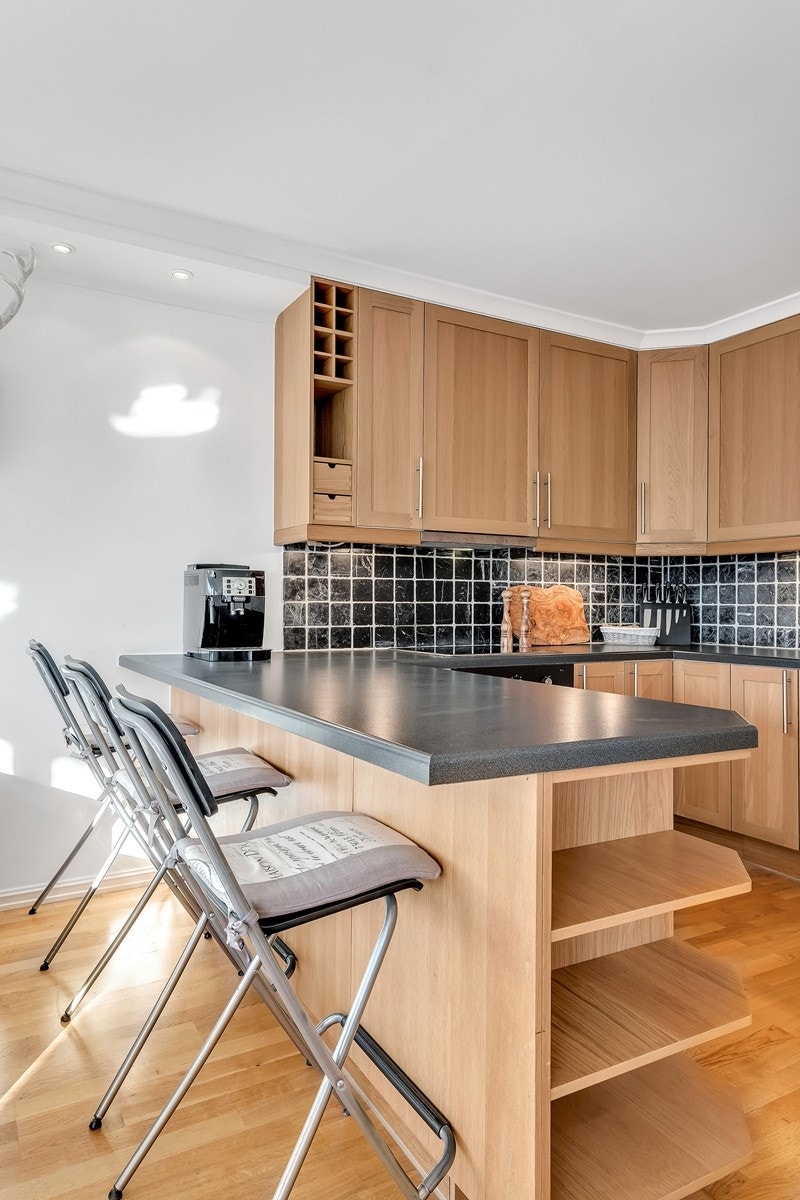 Kjøkkenøy gir ekstra spise- og benkplass i tillegg til å avdele stuen og kjøkkenet på en fin måte Galleribilde