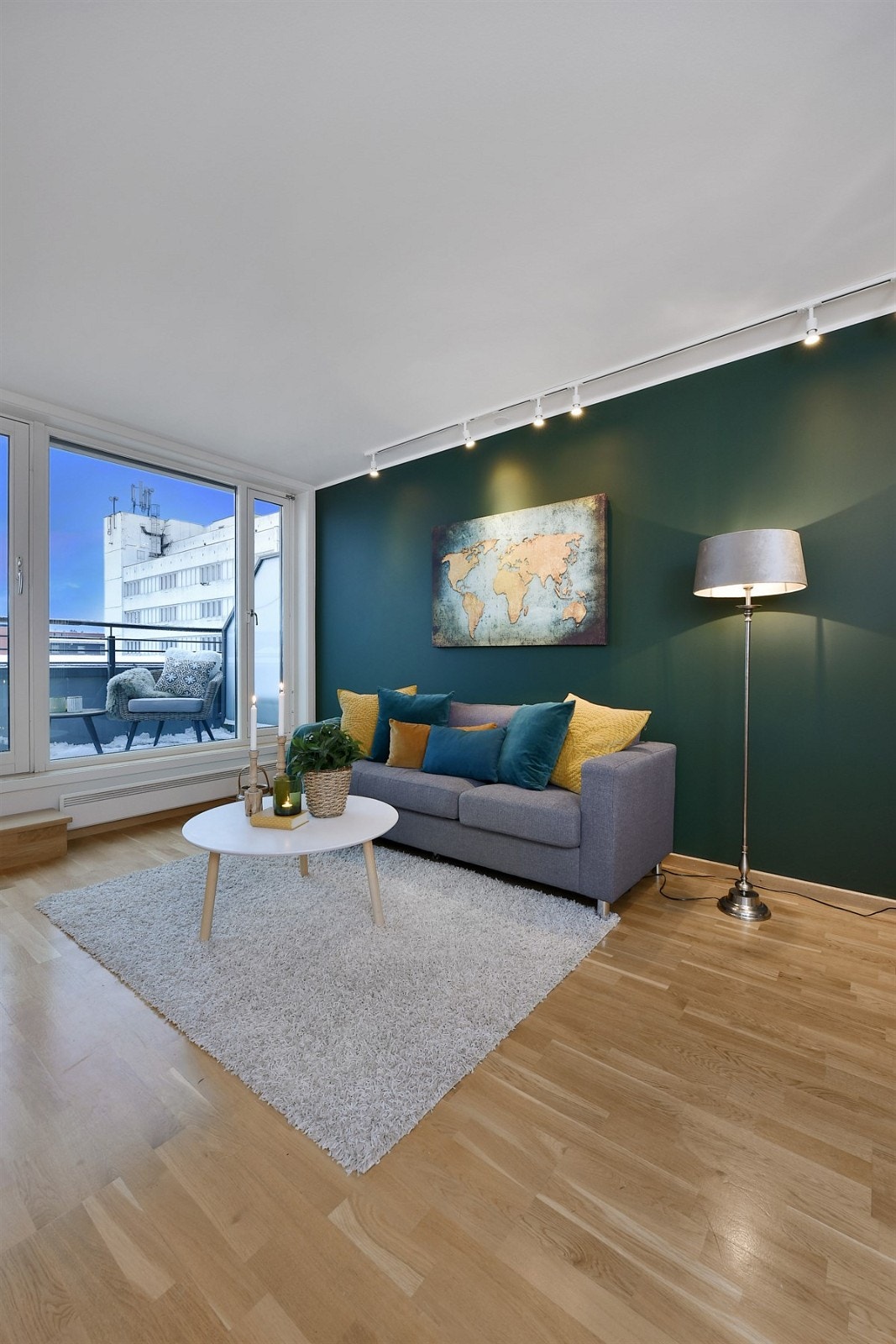 Stuen har tidløs eikeparkett på gulv og hvite vegger, lekkert kombinert med en dypgrønn kontrastvegg. Galleribilde