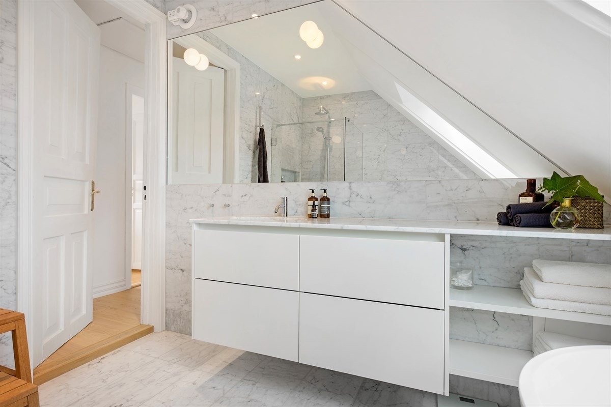 Spesialbygget benkeplate i Italiensk Carrera marmor og Italienske designlamper fra Flos Galleribilde