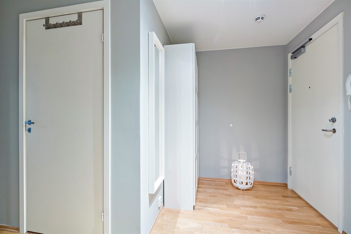 Entréen er lys og har parkett på gulv samt veggflater malt i en delikat farge, noe som gir et godt førsteinntrykk. Galleribilde