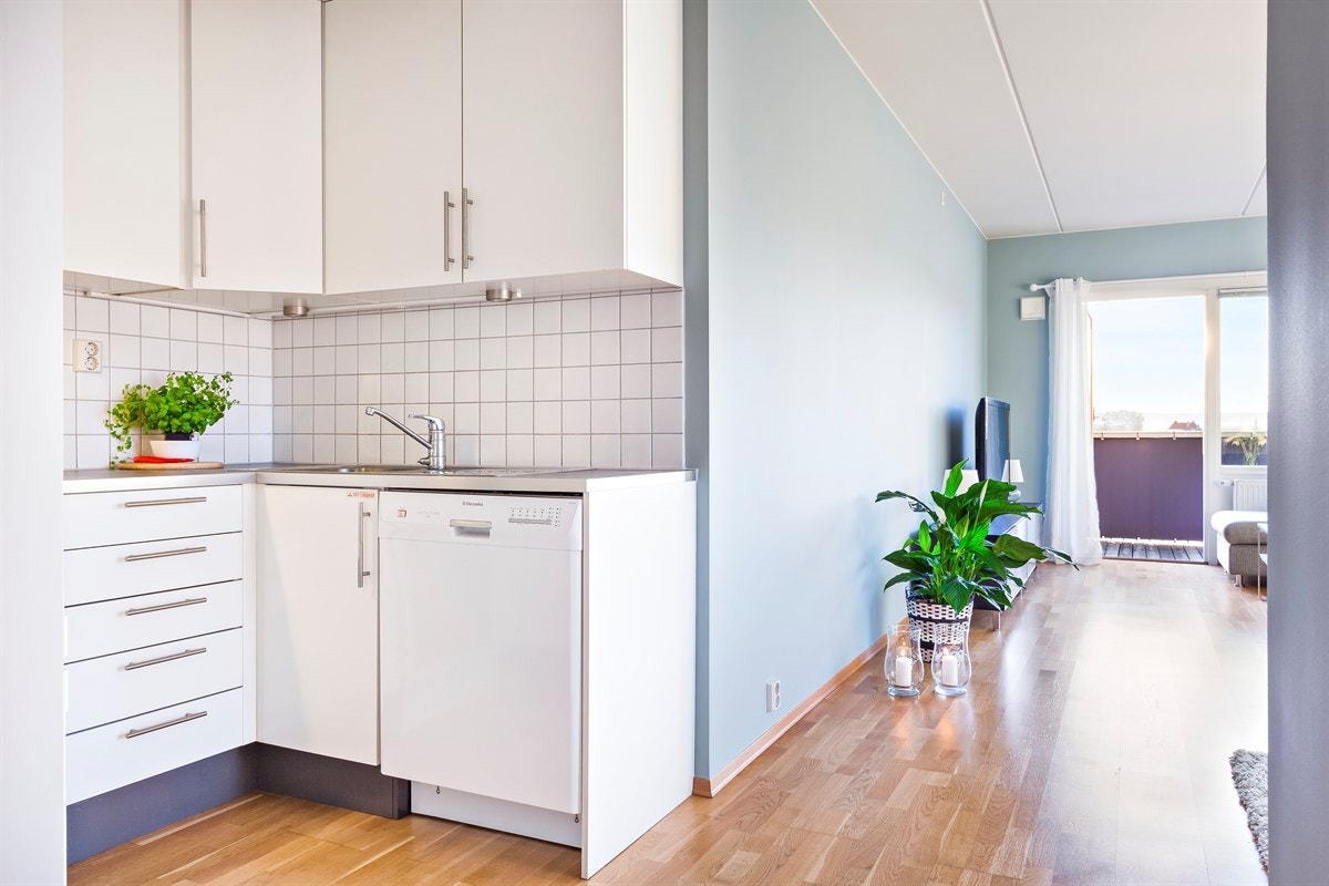 Kjøkkenet er lyst og delikat med parkett på gulv, kjøkkeninnredning med lyse slette fronter, laminat benkeplater samt fliser mellom over- og underskap. Galleribilde