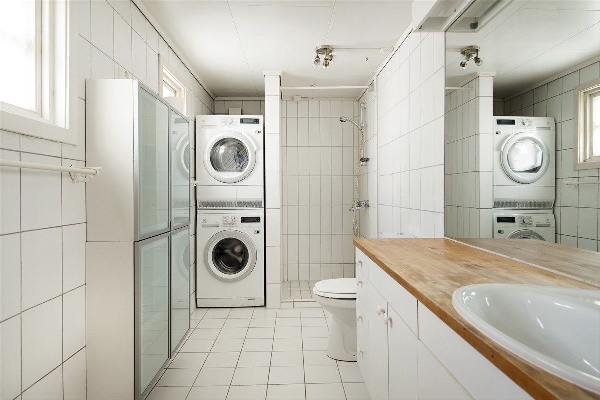 Badet har dusj, toalett, innredning med heltrebenk og nedfelt servant. Opplegg for vaskemaskin og tørketrommel. Galleribilde