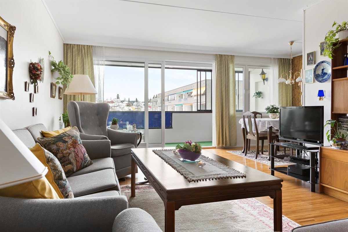 Store vindusflater med stor skyvedører fører ut til en innglasset balkong. Galleribilde