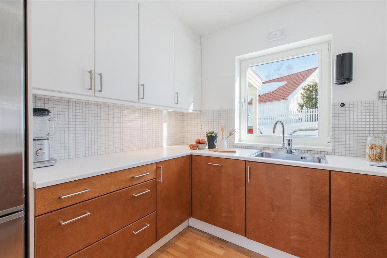 Benkeplate i laminat og mosaikkfliser over benken. Lys under overskap. Galleribilde