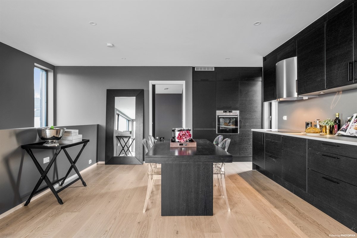 Kjøkkeninnredningen er levert av Norema og har sorte fronter med hvit benkeplate. Galleribilde