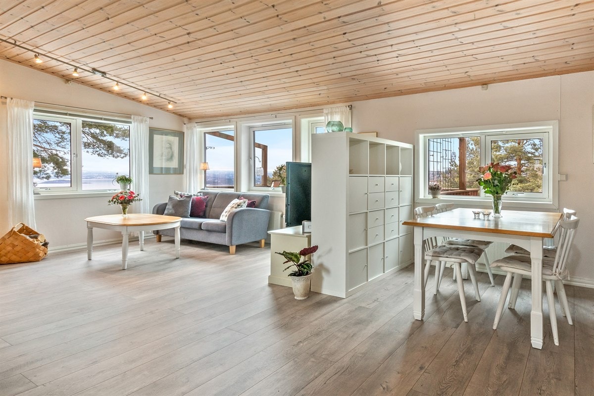 Fra entreen går man videre inn i boligens romslige stue. Enderekkehus gir ekstra vindusflate i stuen og bidrar til en meget lys og god romfølelse. Stuen er delt opp i to soner ved hjelp av en frittstående bokhylle Galleribilde