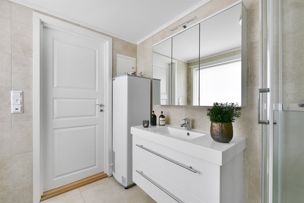 Videre har badet veggmontert toalett, dusjkabinett og opplegg for vaskemaskin. Galleribilde