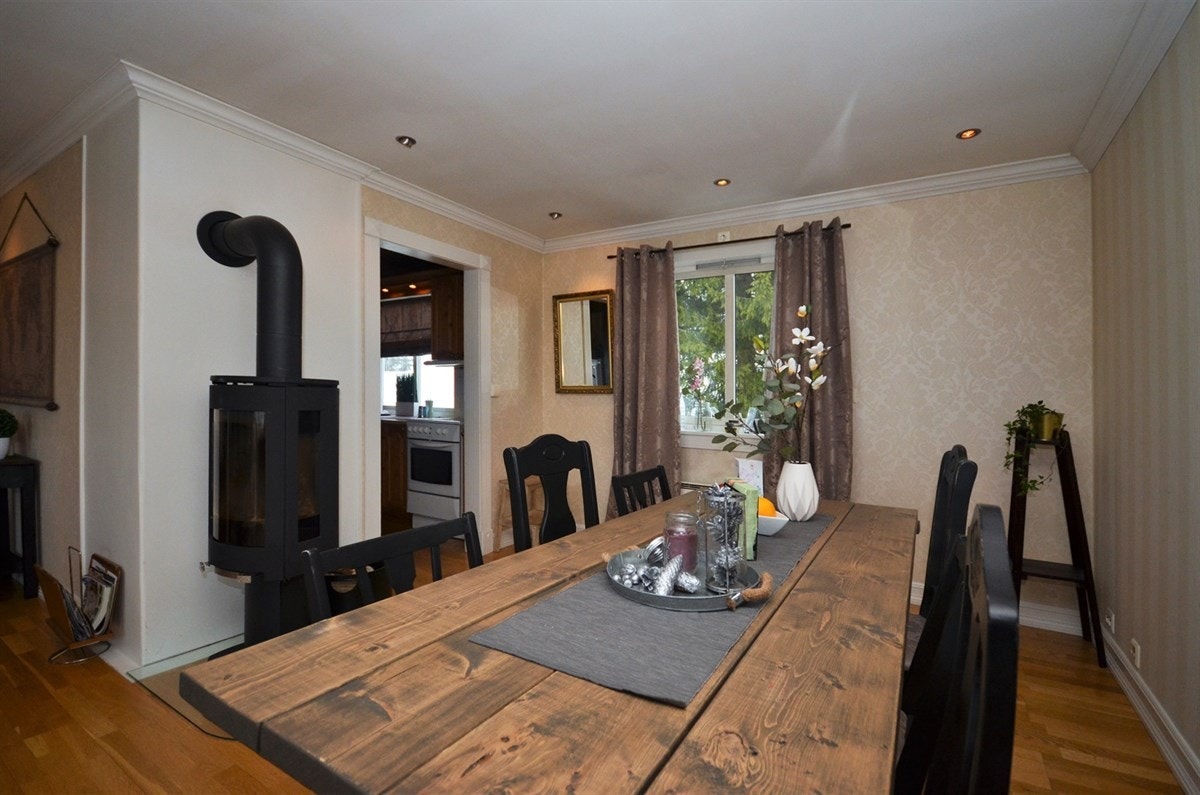 Del av stor spisestuedel med peisovn og adkomst til kjøkken. Galleribilde