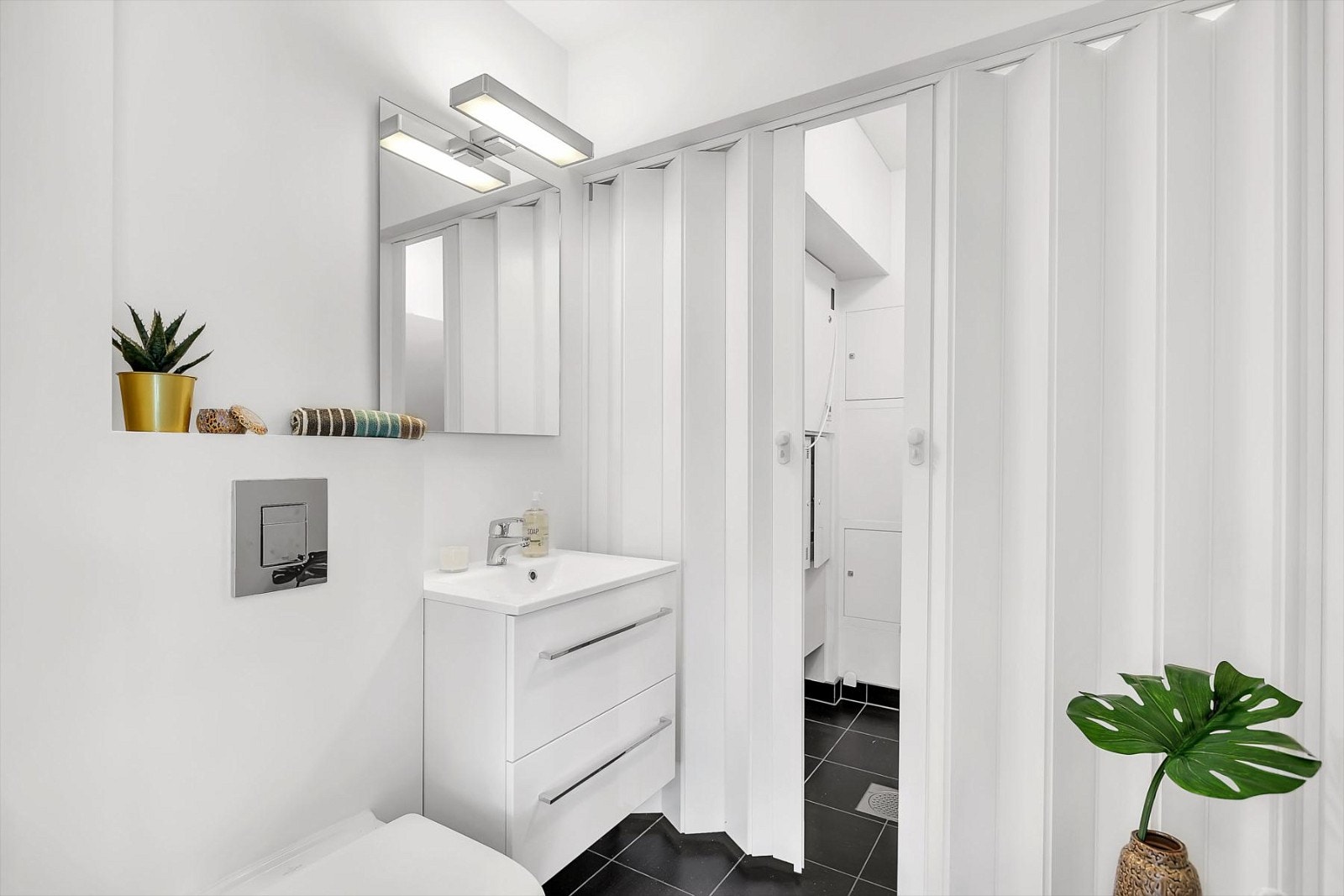 Baderom i første etasje med fortrekksdører inn til teknisk rom Galleribilde