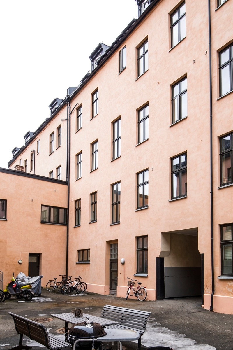 Fasade fra skjermet bakgård med sittegruppe og grill. Galleribilde