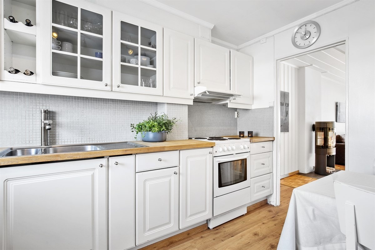 lyst og pent kjøkken med takhøye overskap Galleribilde