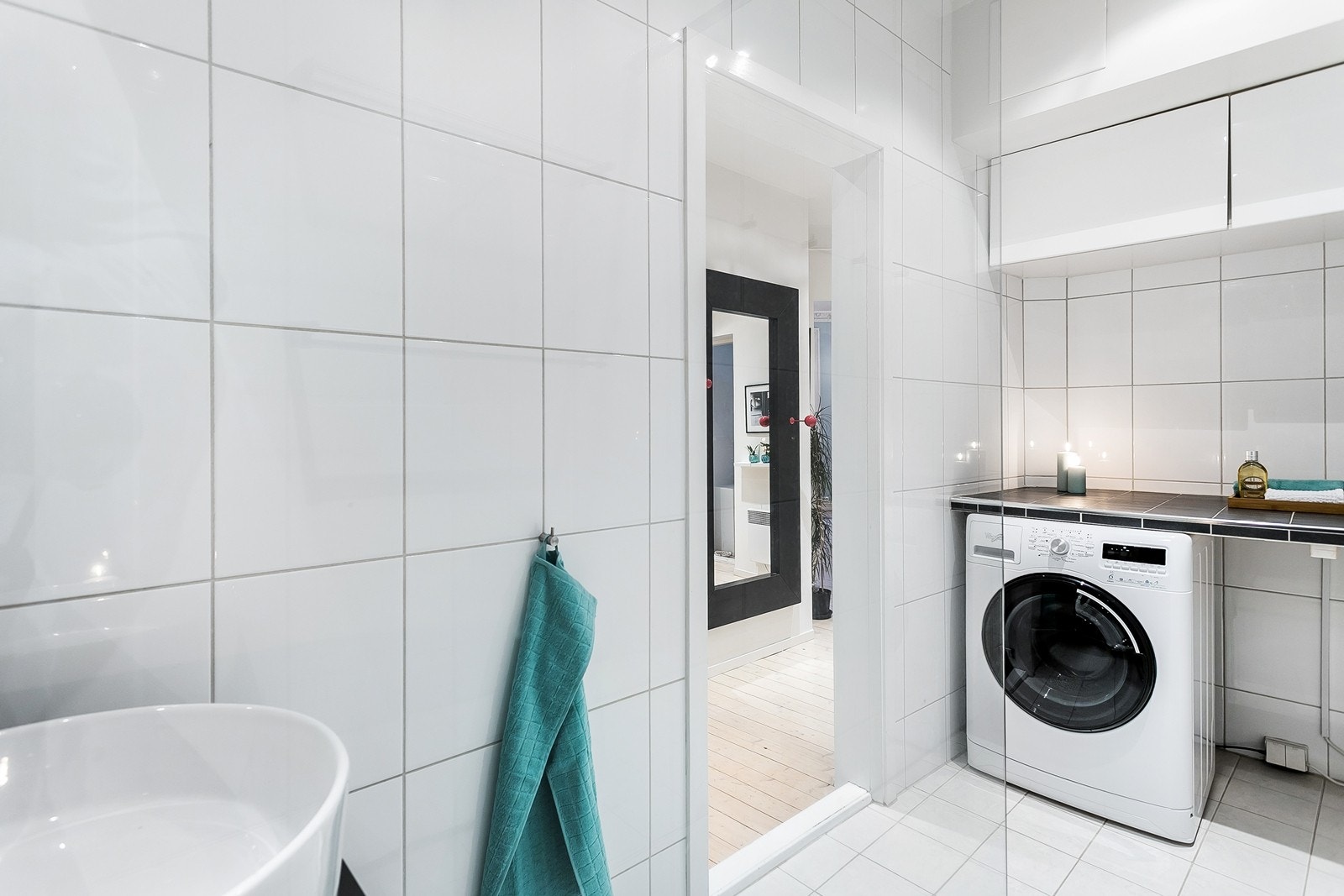 På badet er det også praktisk benkeplate med opplegg til vaskemasin under, samt innredning over. Galleribilde