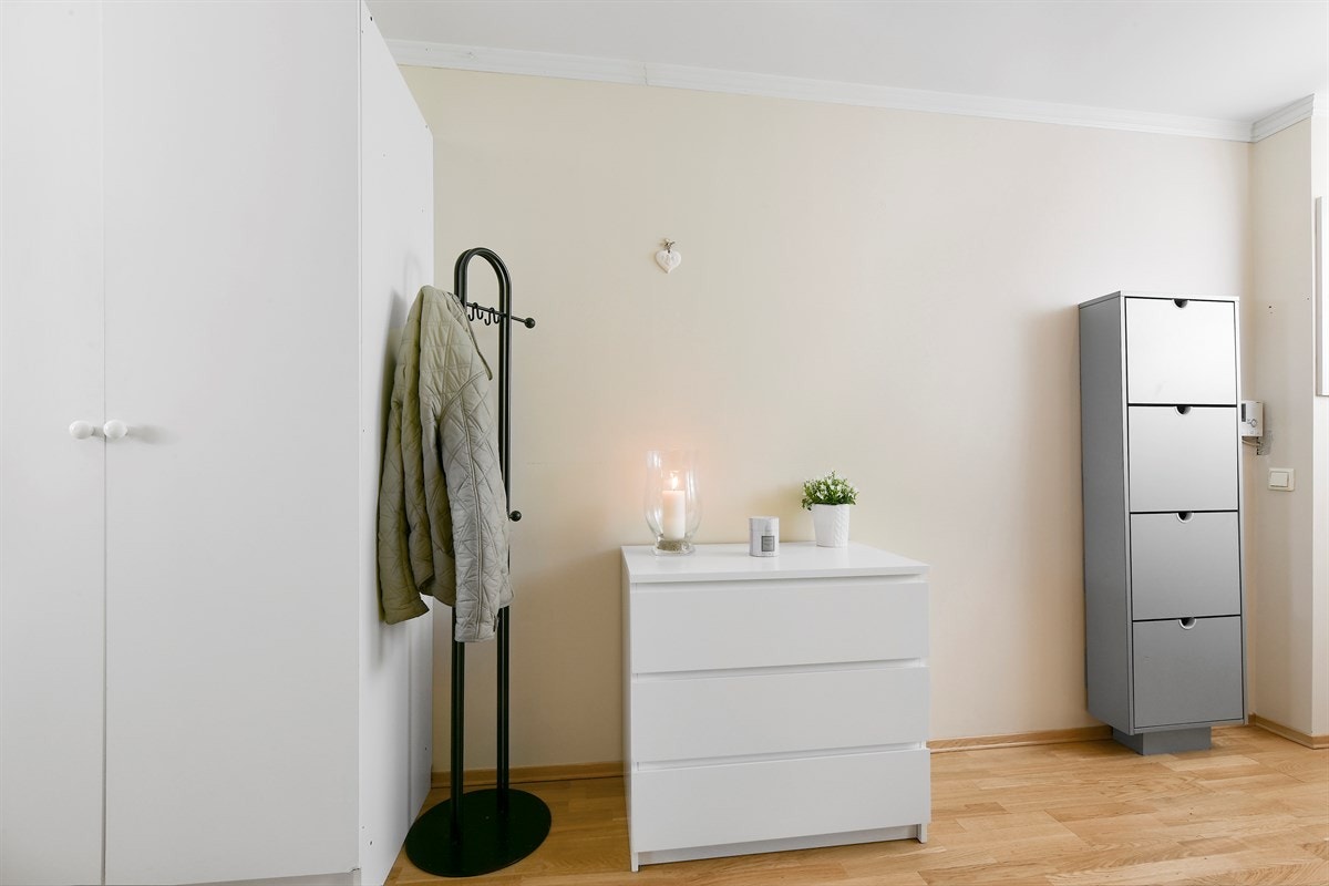 Entreen har parkett på gulv og lysmalte veggflater. Galleribilde