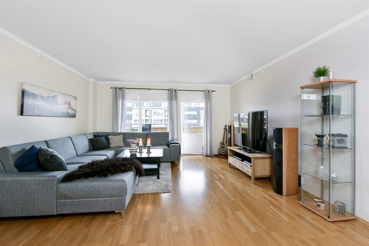 Stuen er romslig og har store vindusflater som gir rikelig med lys, samt utgang til overbygget veranda. Galleribilde