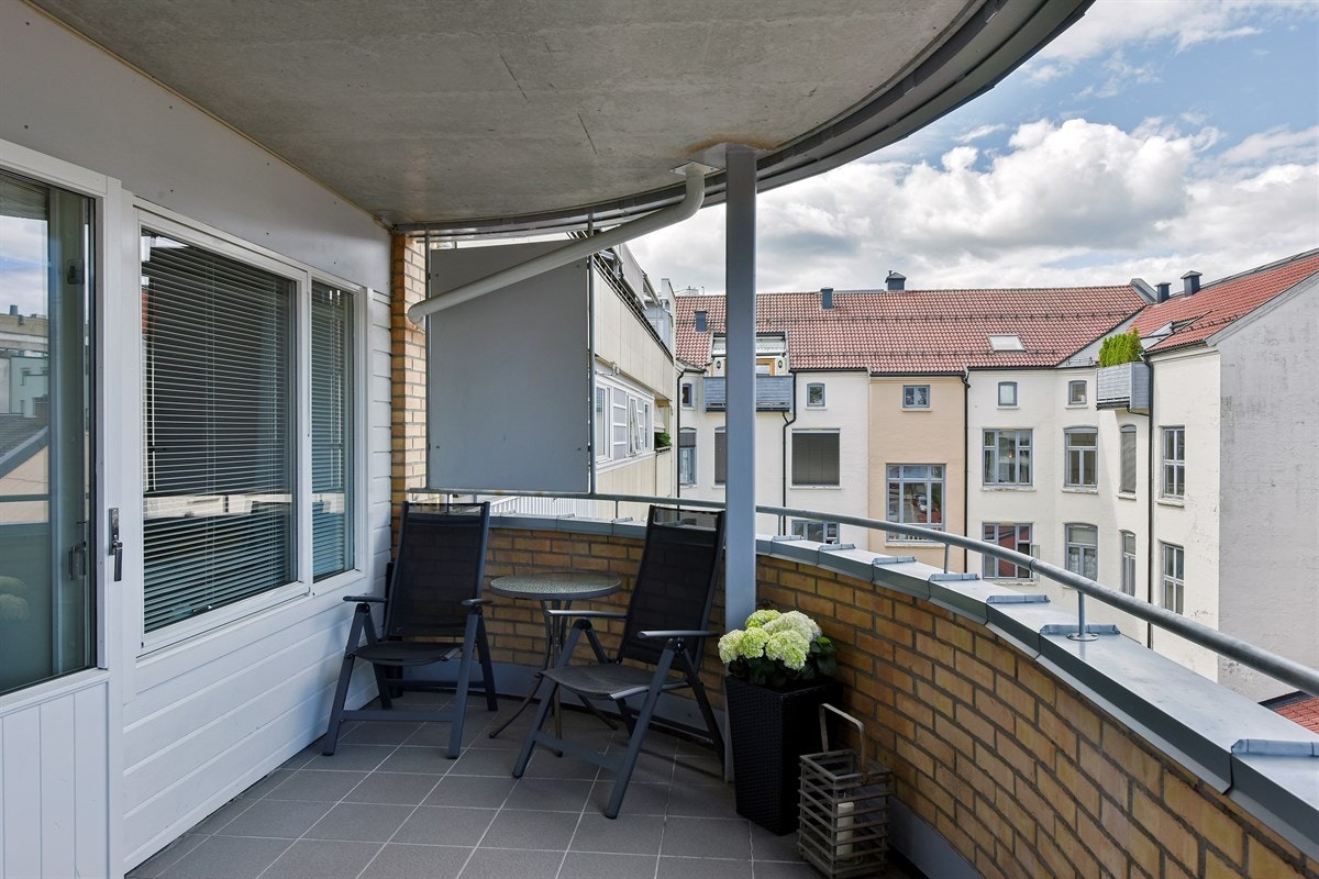 Verandaen har flislagt dekke og tett rekkverk i teglstein, slik at privatlivet opprettholdes. Galleribilde