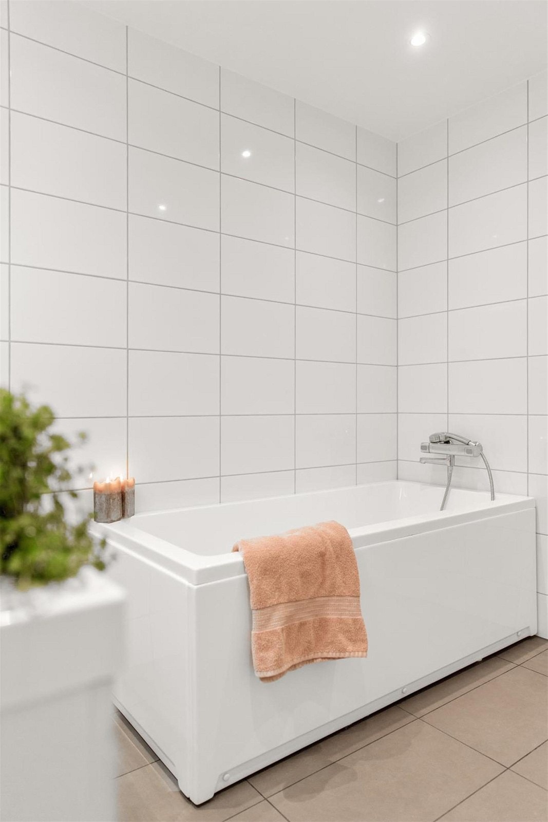 Helfliset bad i duse farger. Innredet med vegghengt toalett, servant med møblement og badekar. Galleribilde