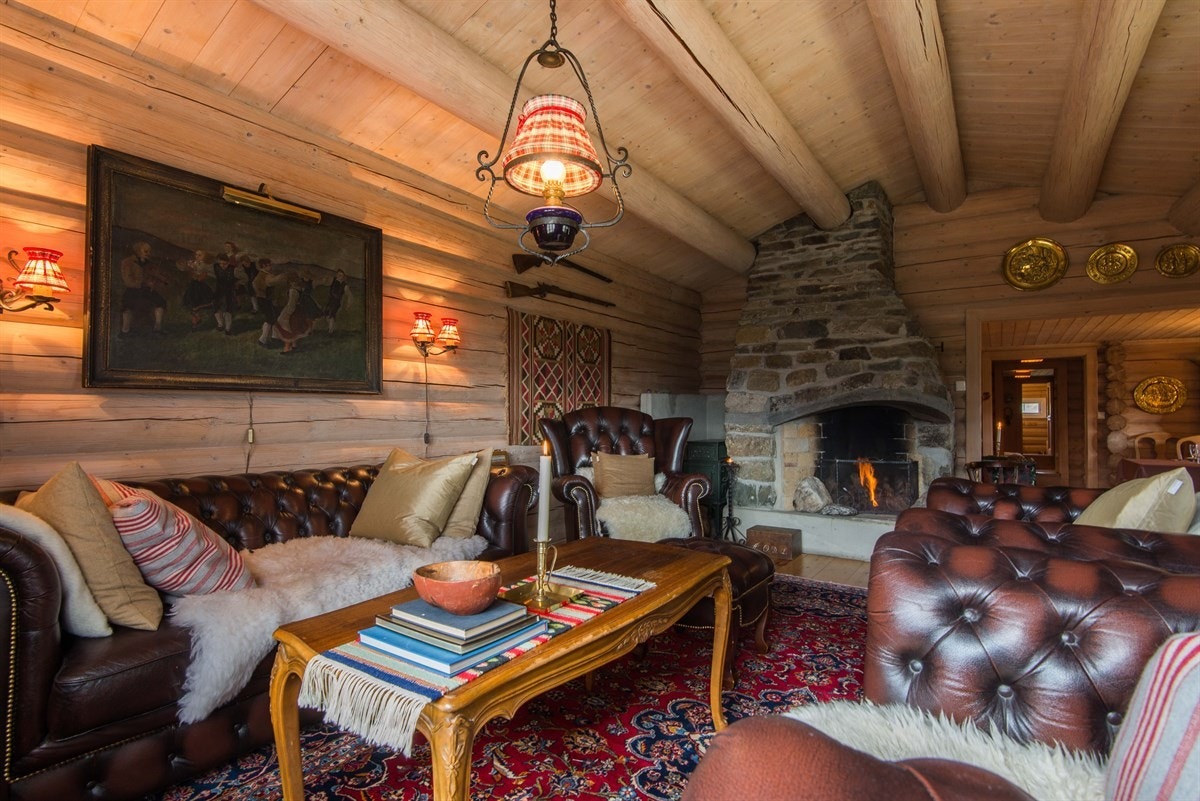 En stor, åpen peis forblendet med naturstein gir en lun og hyggelig atmosfære. Galleribilde