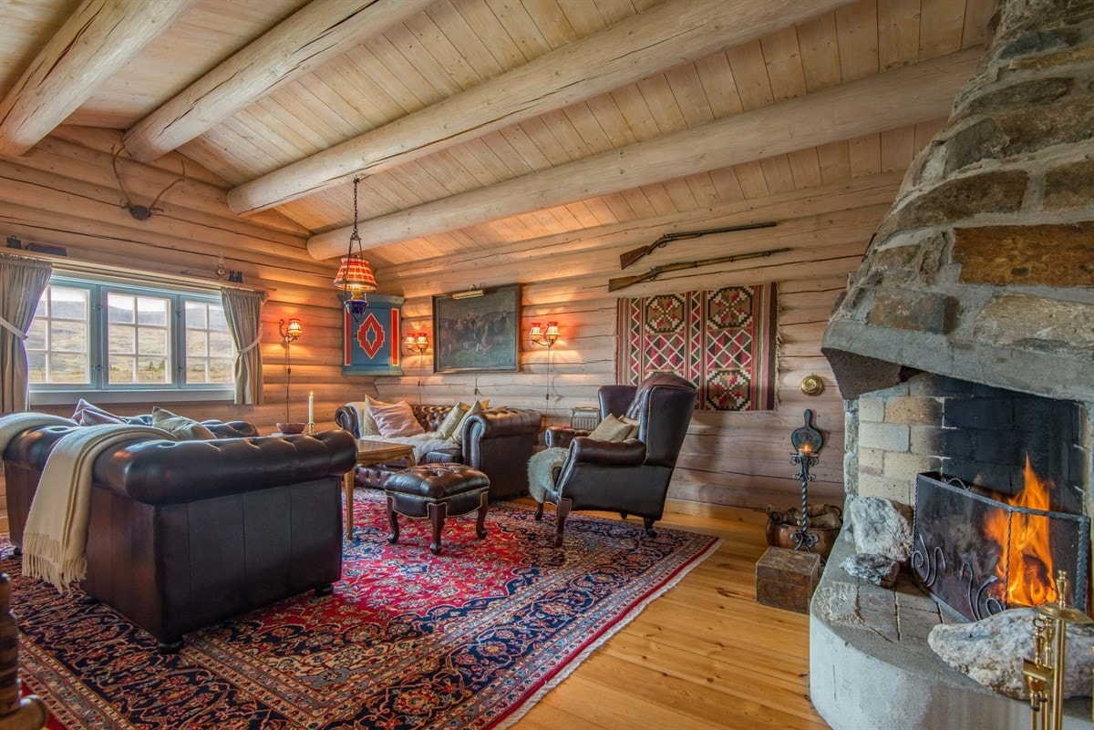 Stua er åpen og luftig med mønet himling og fem kraftige tømmeråser. Galleribilde