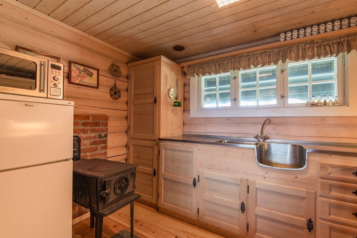 Innredningen er i furu, har vakre smijernsbeslag og godt med skapplass. På kjøkkenet er det også plassert en stor vedovn. Galleribilde