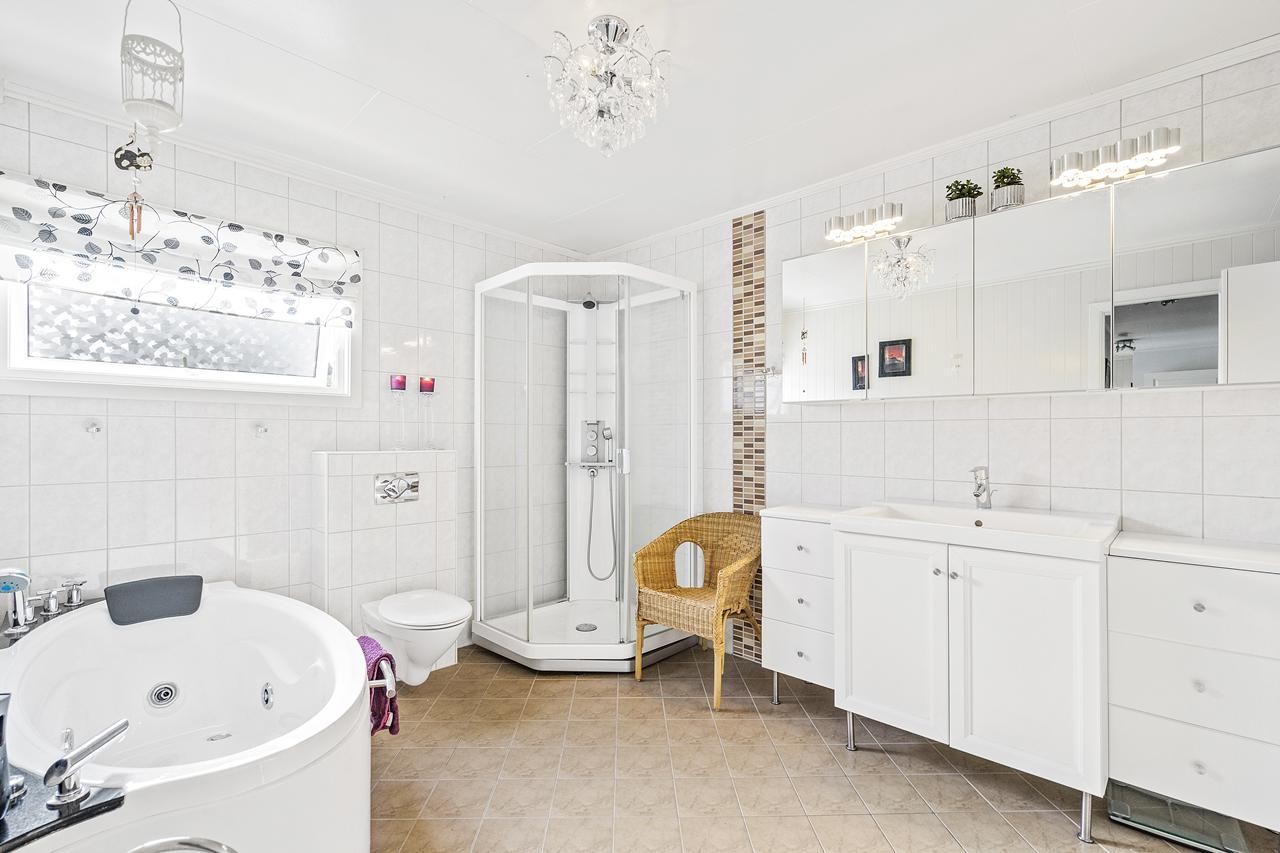 Bad m/dusjkabinett og innredning m/nedfelt servant samt over og underskap. Galleribilde