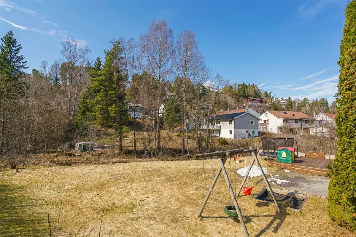 Tomten på drøye 1 mål har en stor, singlet gårdsplass og solrik hage godt tilrettelagt for herlig sommerhygge. Galleribilde