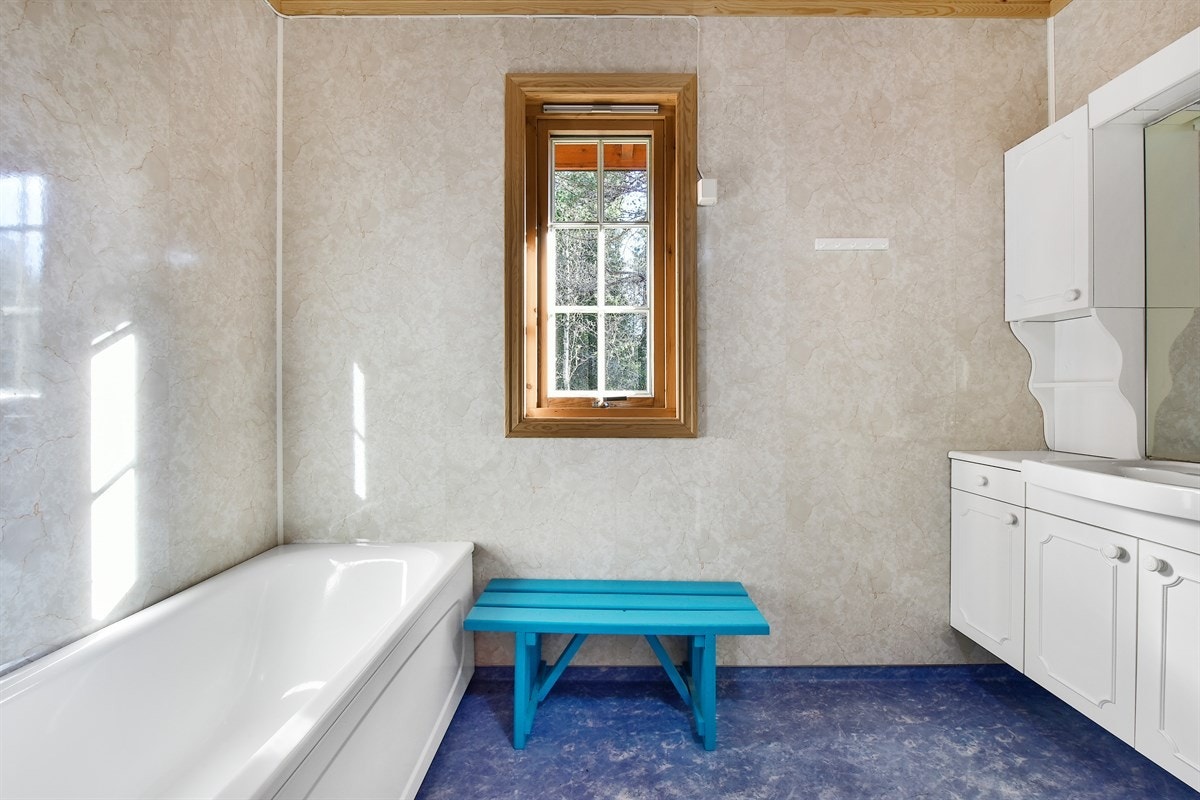 Badet har blått belegg på gulv med gulvvarme og baderomsplater på veggene. Galleribilde
