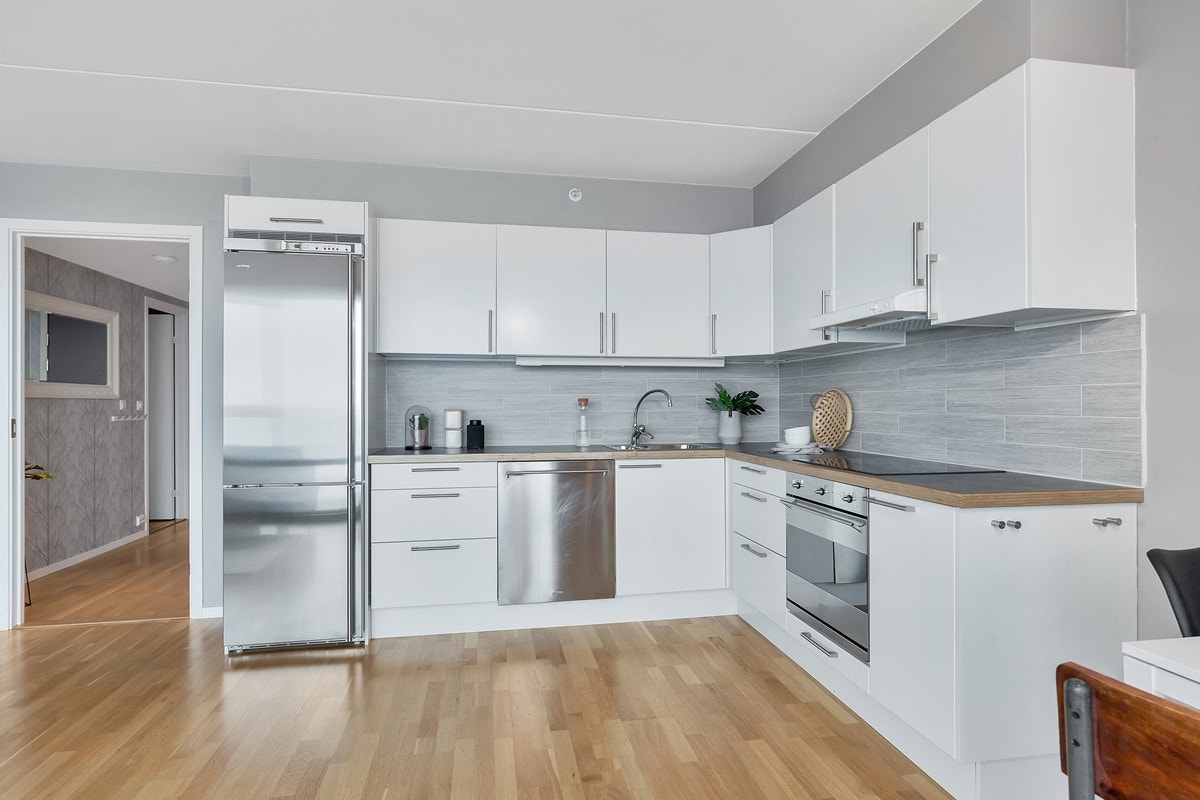 Kjøkken - mørke benkeplater med nydeligge fliser mellom skap og benk Galleribilde