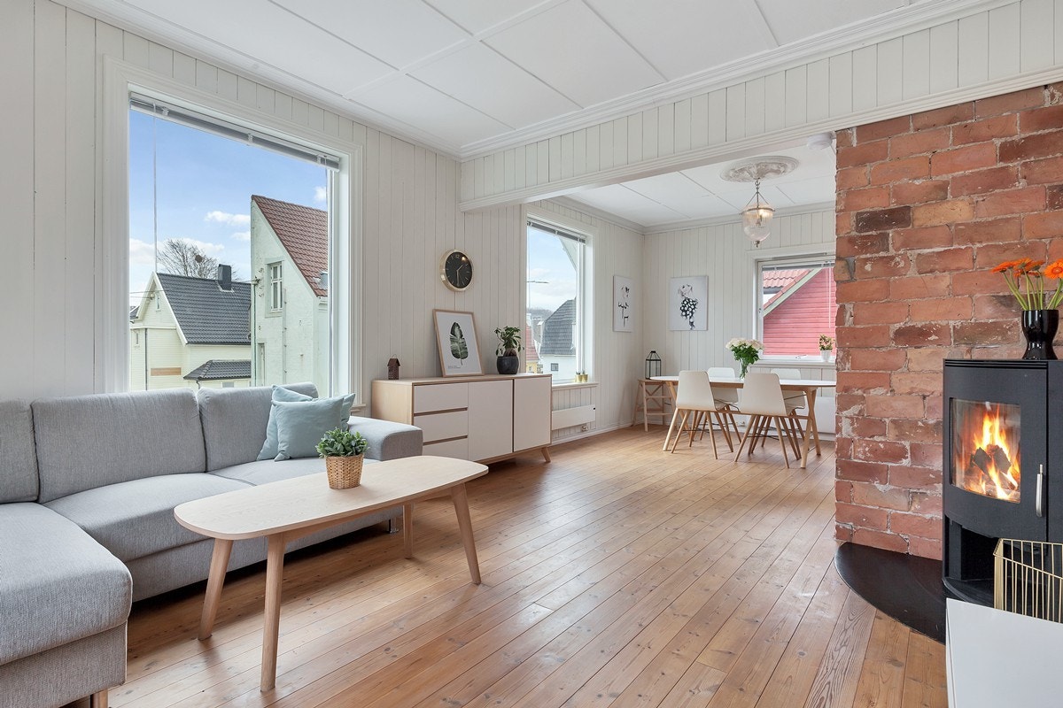 Stue i hvite overflater med kontrast fra pipen midt i rommet Galleribilde