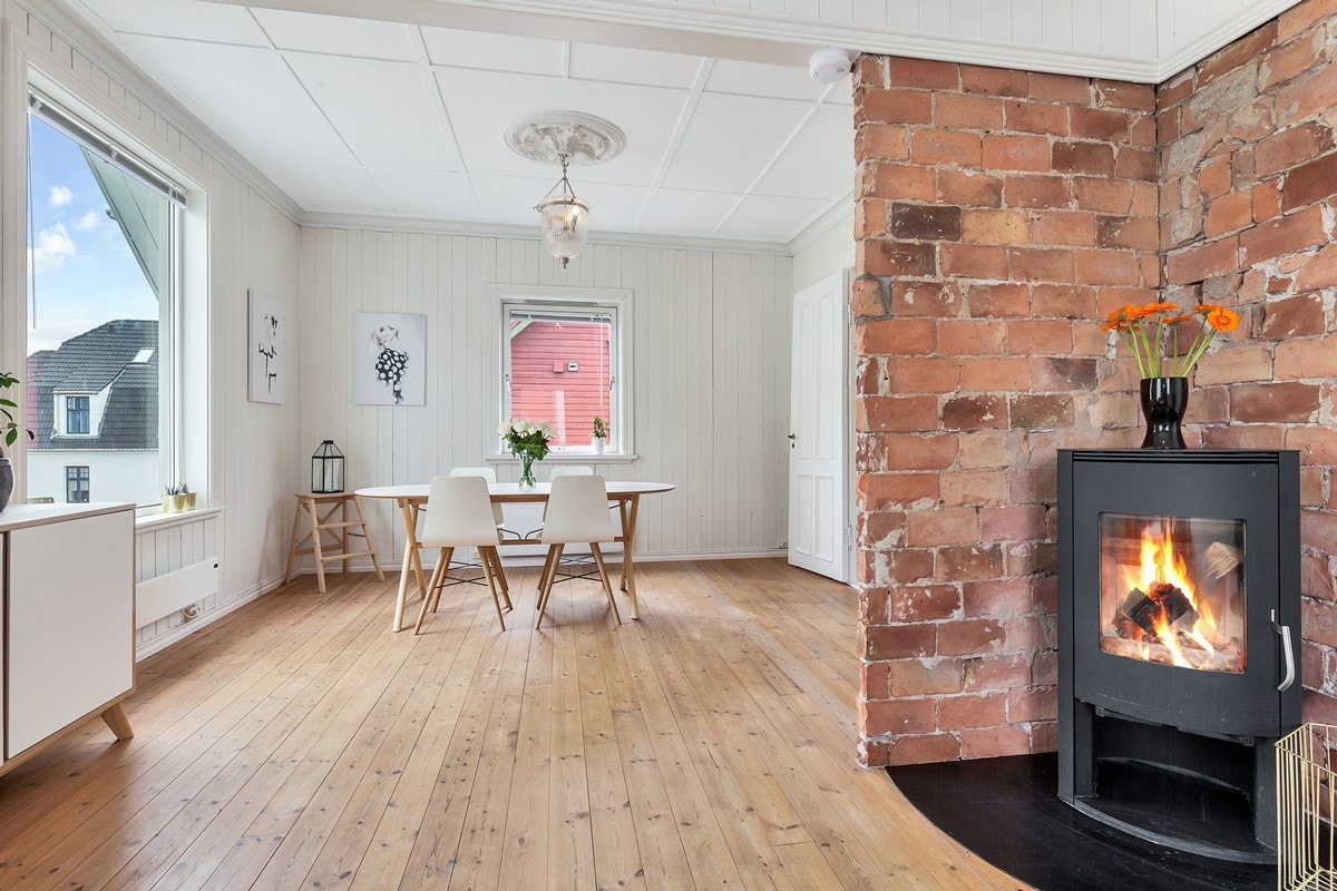 Stuen har godt bevart tregulv og peis av nyere dato Galleribilde