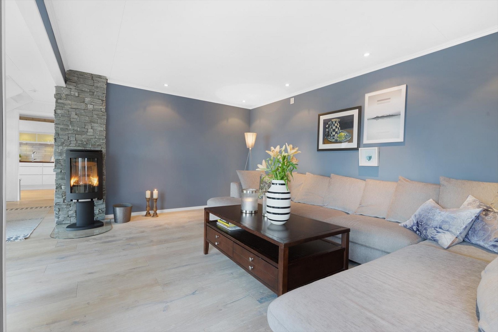 Vedfyrt ovn gir deg en lun varme selv om behovet for ekstra fyring sjelden er til stedet - Pipen er kledd med pyntestein Galleribilde