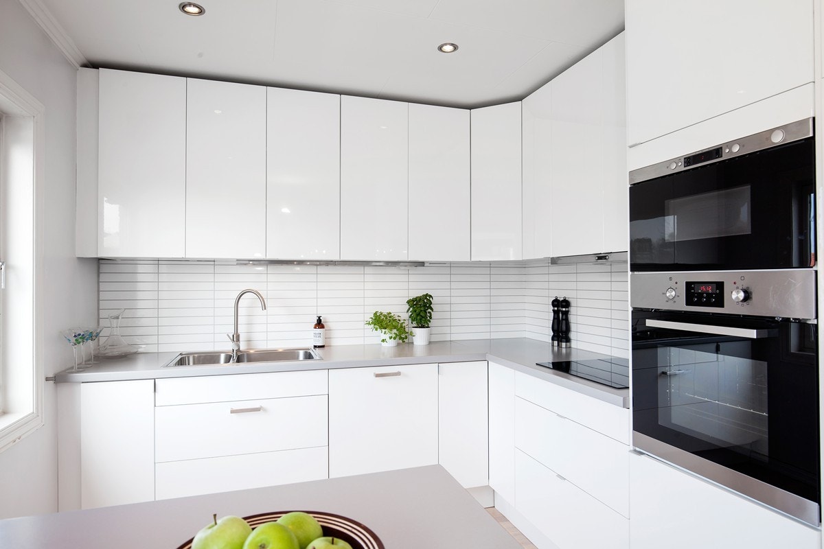 Lys og innbydene kjøkken med nyere hvitevarer og spotter i tak Galleribilde