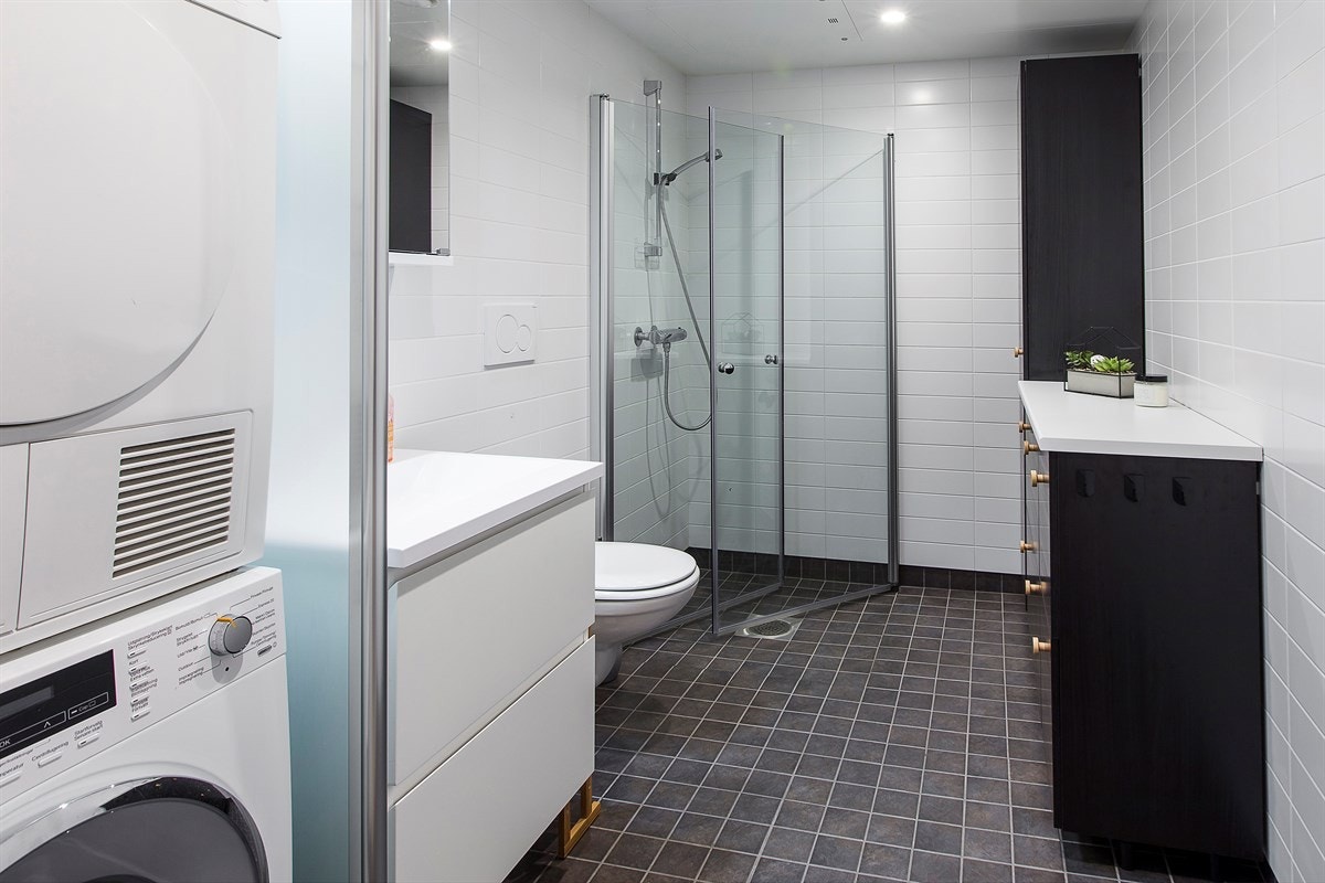 Delikat flislagt bad med dusjnisje og opplegg for vaskesøyle Galleribilde