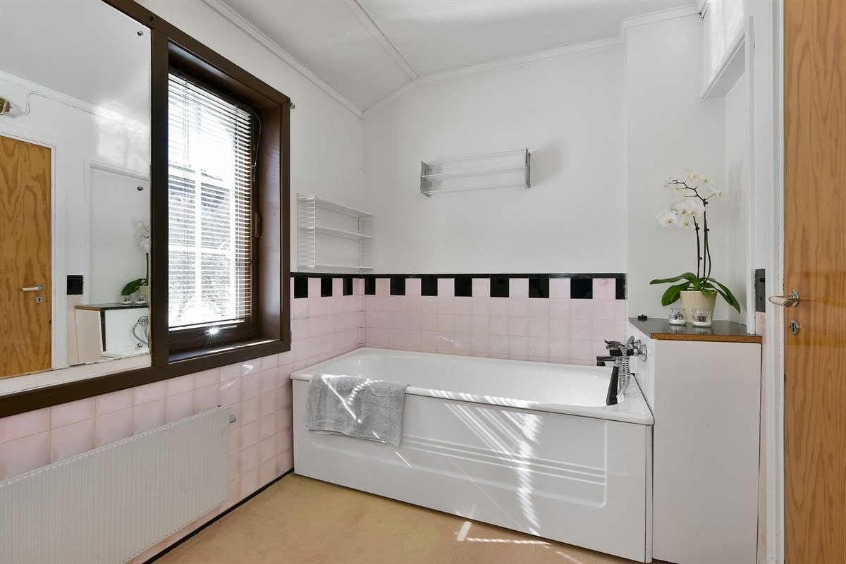 Det andre badet ligger i andre etasje og har teppe på gulv, malte vegger og to gode vinduer. Galleribilde