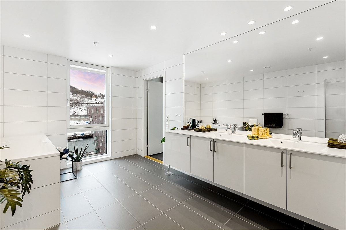 Det ene badet ligger i tilknytning til hovedsoverommet, og fremstår som et romslig velværebad med regnfallsdusj og boblebadekar. Galleribilde